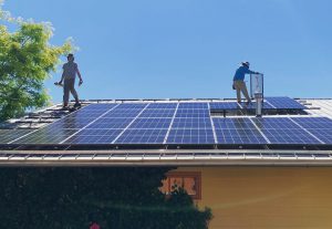 ARE Solar employees installing solar panels on a residential roof