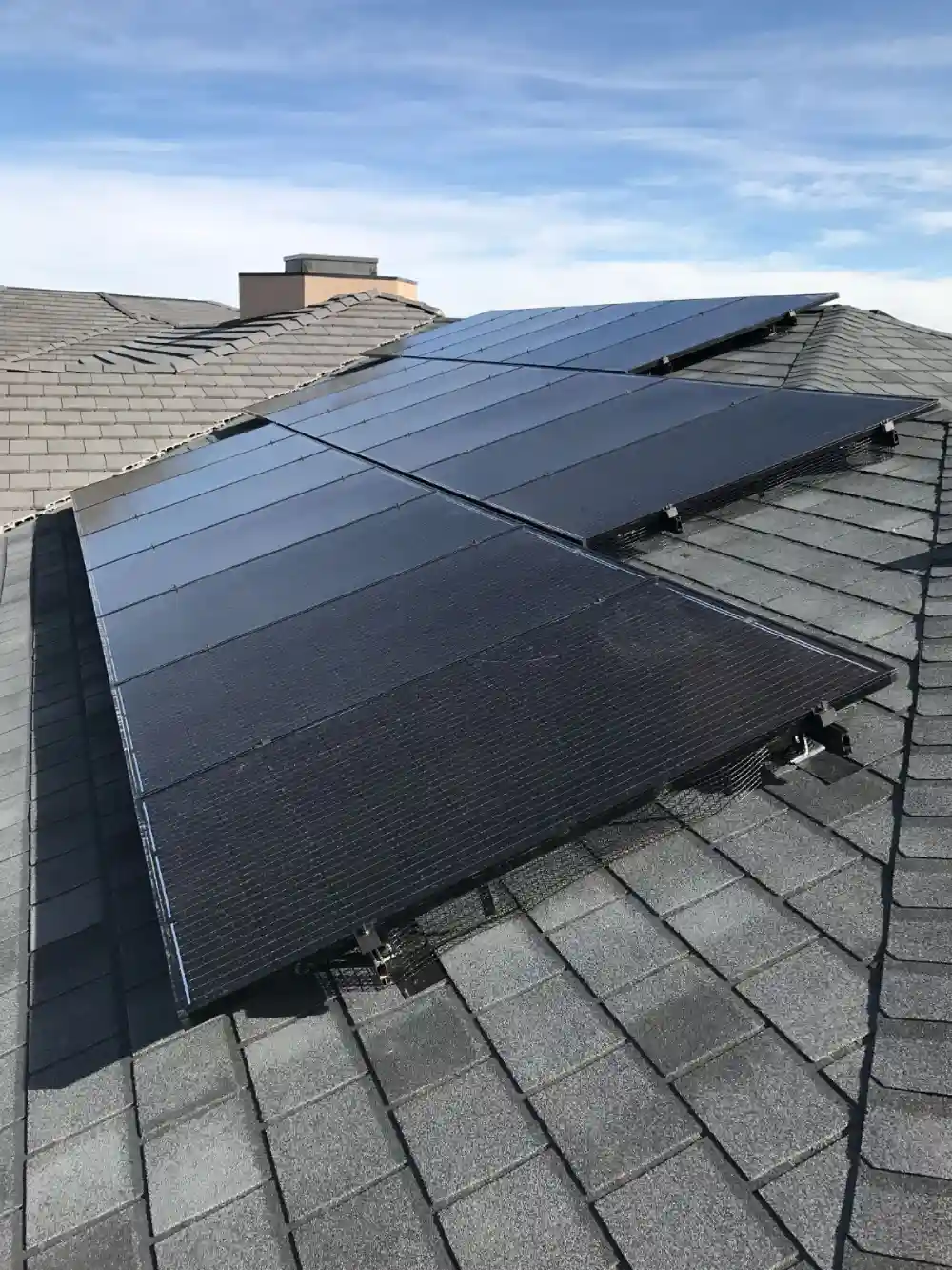 Residential solar system on a large Erie home under a bright blue sky