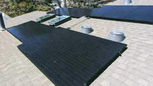 Rooftop solar panel installation on a residential home with skylights and vent tubes