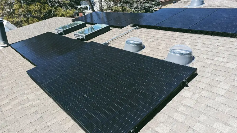 Rooftop solar panel installation on a residential home with skylights and vent tubes