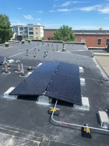 Rooftop solar panels on a Denver commercial building with conduit connections for clean energy savings