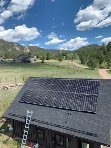 Solar panels being installed on a residential roof with rolling green hills