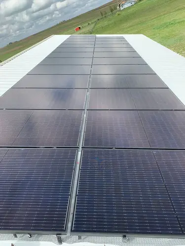 Solar panels soaking sunlight by green fields — clean energy powering retail centers and cutting commercial costs